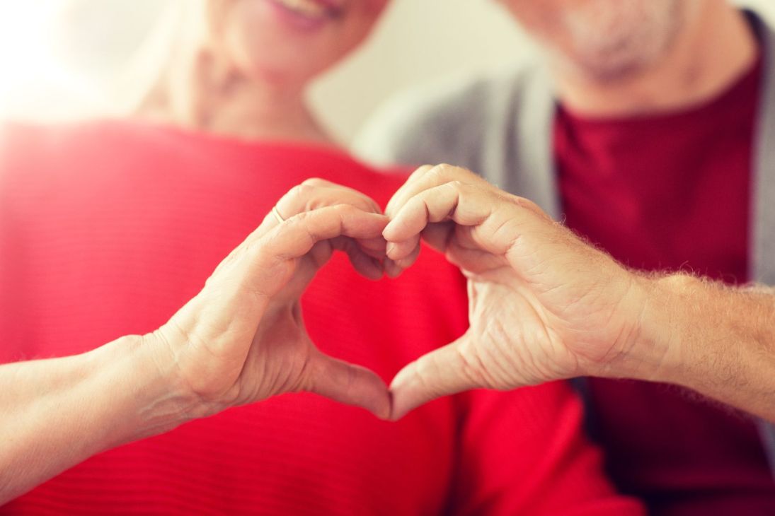 Close up of hands making the shape of a heart.