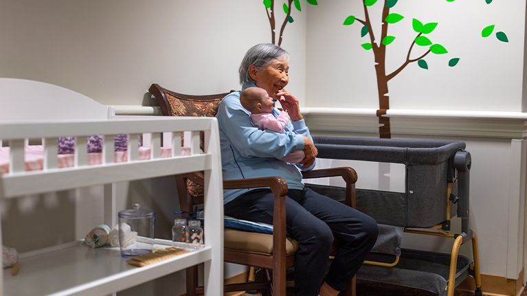 Masonicare resident holding baby toy
